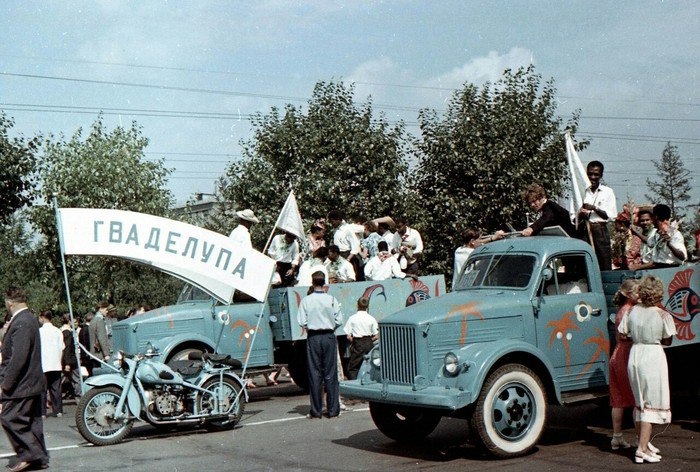 Делегация Гваделупы на Всемирном фестивале молодежи и студентов в 1957 году На фотографии пара специально разукрашенных ГАЗ-51 и мотоцикл с коляской Ирбитского мотоциклетного завода с растяжкой Гваделупа.jpg